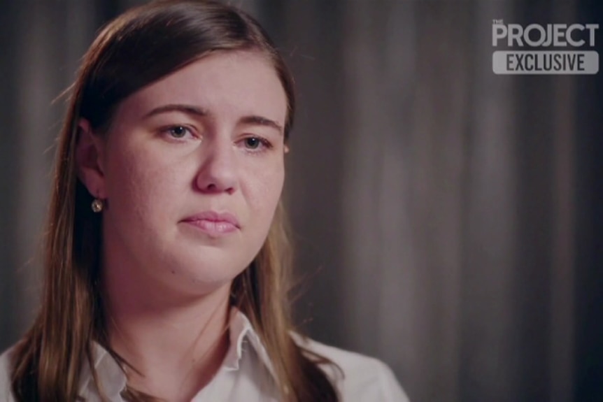 A woman with light brown hair looks on the verge of tears.